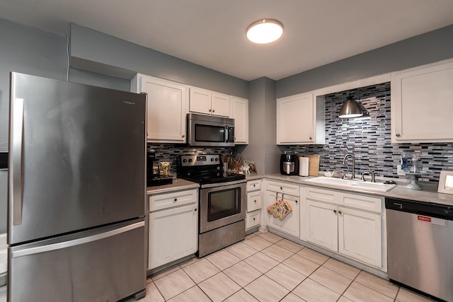 kitchen featuring stainless steel appliances, sink, light tile patterned floors, and tasteful backsplash