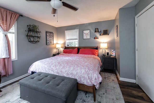 bedroom with multiple windows, ceiling fan, and dark hardwood / wood-style floors