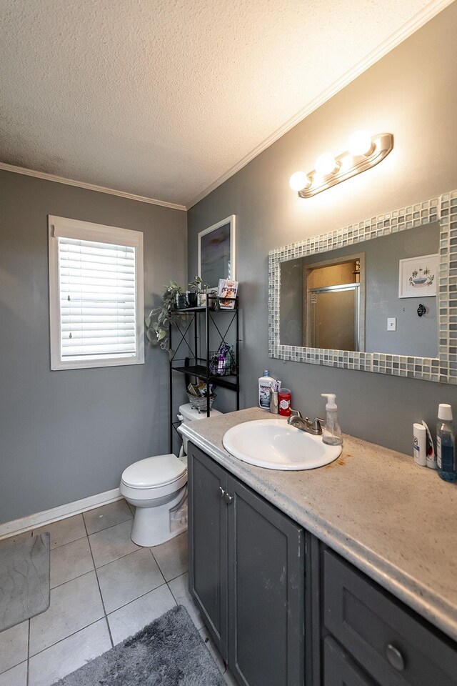 bathroom with a textured ceiling, vanity, toilet, ornamental molding, and tile patterned floors