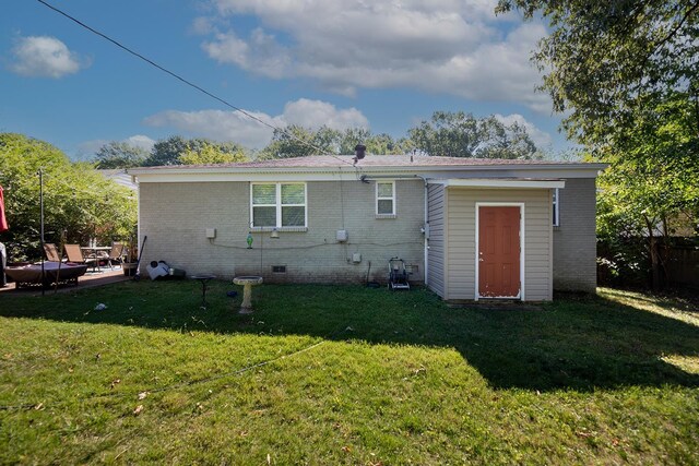 rear view of property with an outdoor structure and a yard