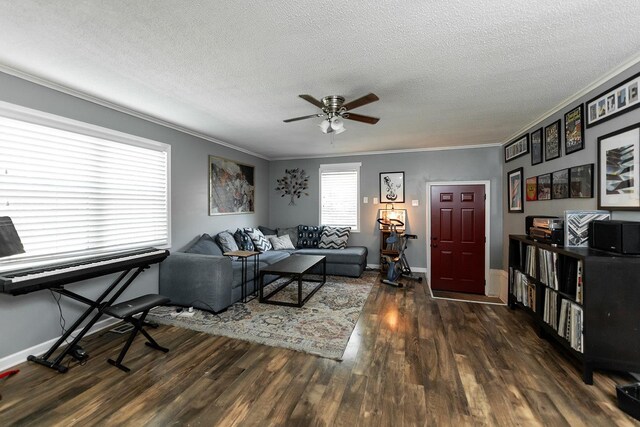 living room with a textured ceiling, ceiling fan, ornamental molding, and dark hardwood / wood-style flooring