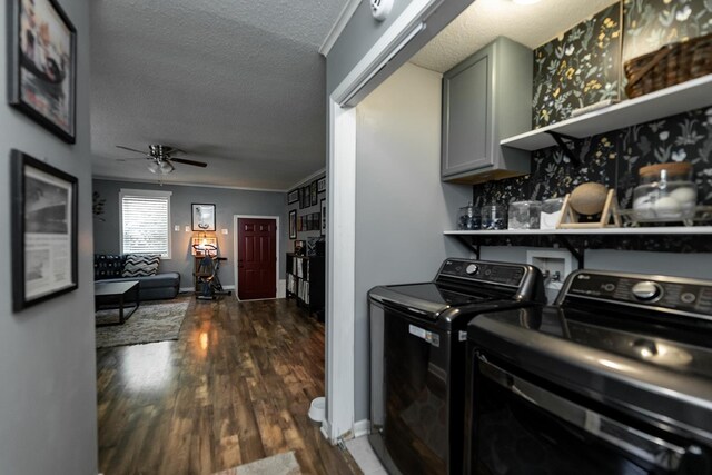 clothes washing area featuring cabinets, a textured ceiling, washing machine and dryer, ceiling fan, and dark hardwood / wood-style floors