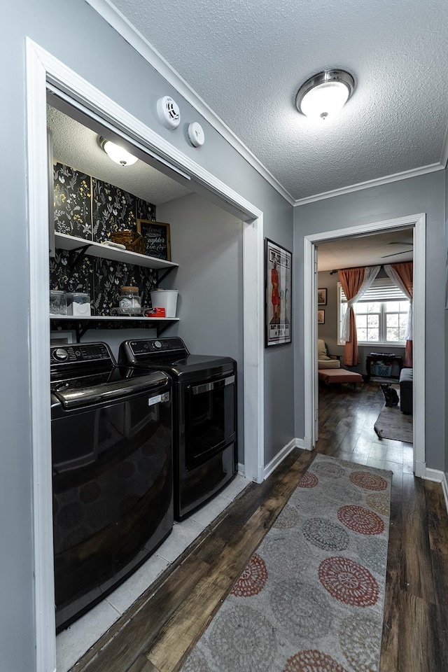 bar with crown molding, a textured ceiling, hardwood / wood-style flooring, and washing machine and clothes dryer