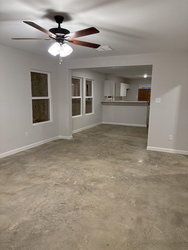 unfurnished living room featuring concrete floors and ceiling fan