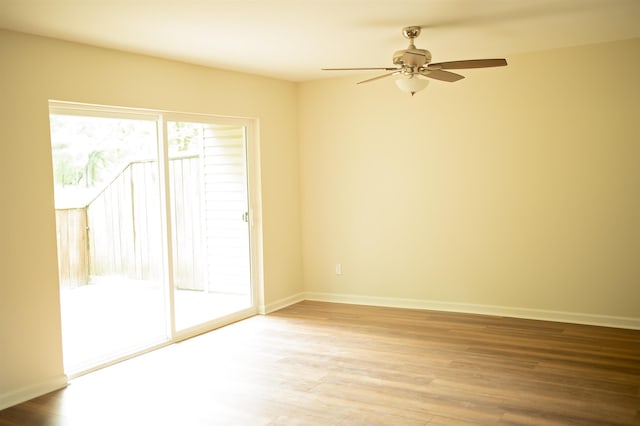 empty room with ceiling fan, baseboards, and wood finished floors