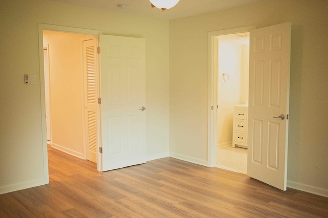 unfurnished bedroom featuring wood finished floors and baseboards