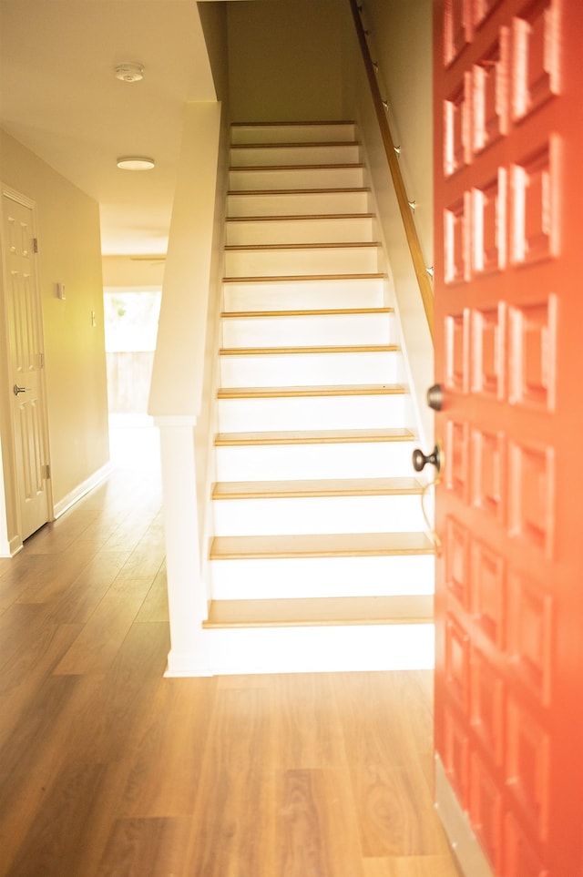 staircase with hardwood / wood-style flooring