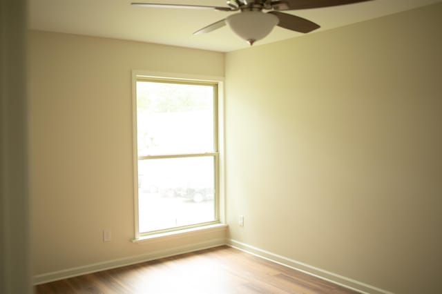 unfurnished room featuring light wood-style floors, baseboards, and a ceiling fan