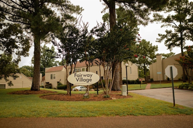 community / neighborhood sign with a yard