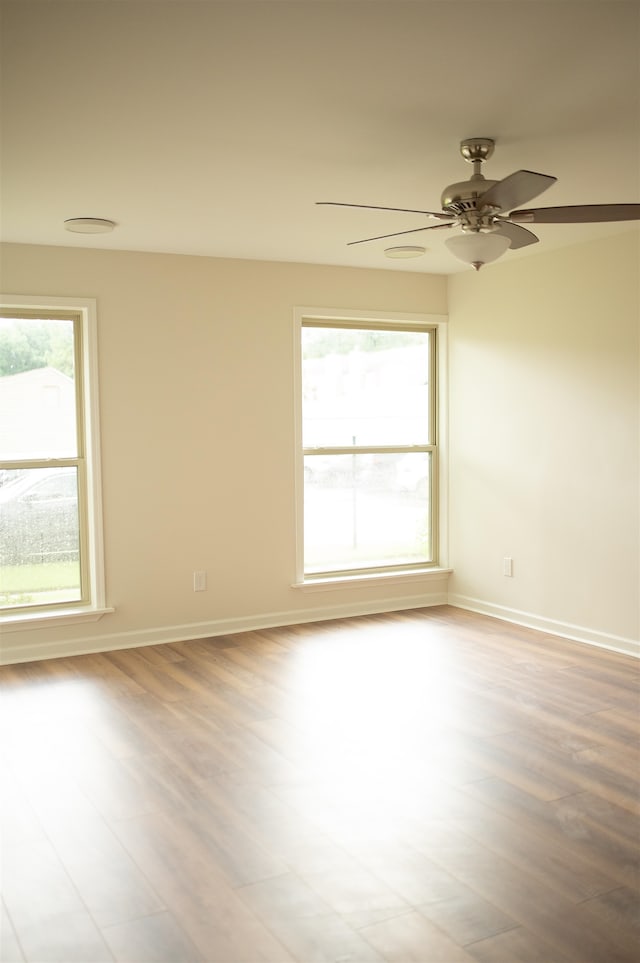 spare room with ceiling fan and light wood-type flooring