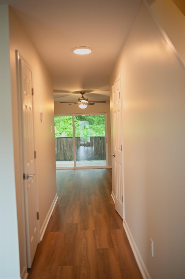 hallway with baseboards and wood finished floors