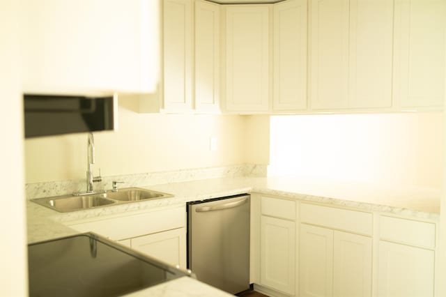 kitchen with stainless steel dishwasher, white cabinets, a sink, light stone countertops, and range