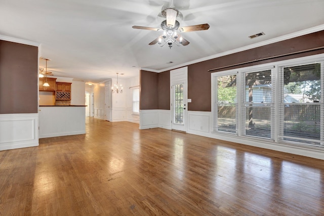 unfurnished living room featuring light hardwood / wood-style floors, ceiling fan with notable chandelier, and ornamental molding