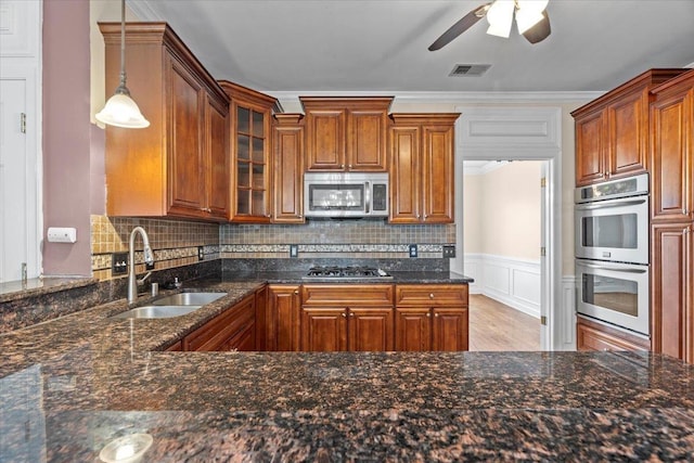 kitchen with visible vents, appliances with stainless steel finishes, brown cabinets, and a sink