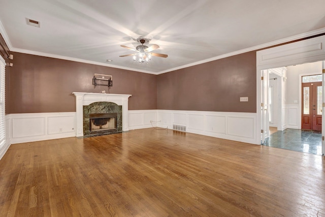 unfurnished living room featuring ceiling fan, hardwood / wood-style floors, crown molding, and a premium fireplace