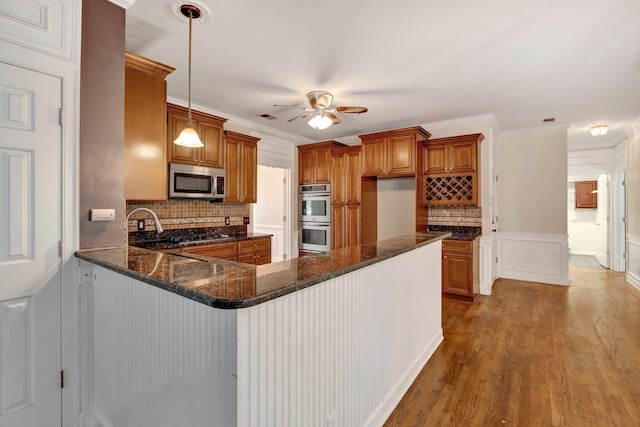 kitchen with stainless steel appliances, tasteful backsplash, ceiling fan, hardwood / wood-style flooring, and hanging light fixtures