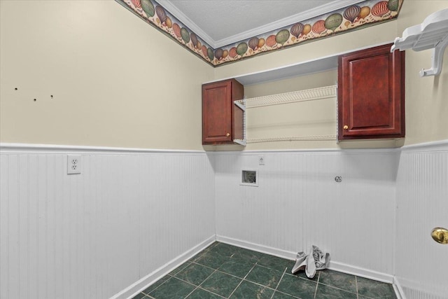 laundry room featuring cabinet space, wainscoting, hookup for a washing machine, a textured ceiling, and crown molding