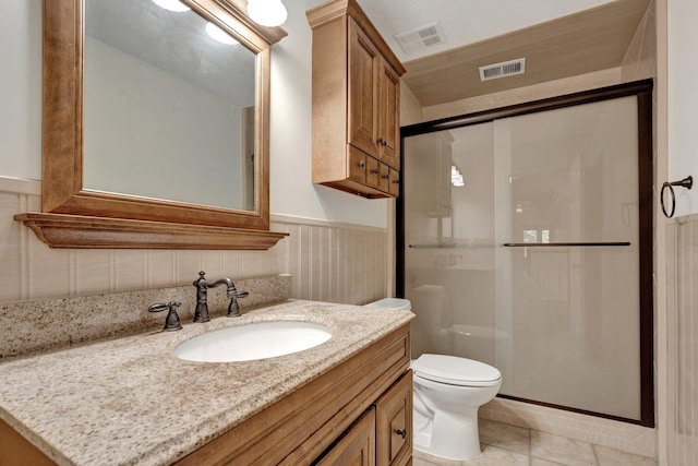 bathroom with tile patterned flooring, an enclosed shower, vanity, and toilet