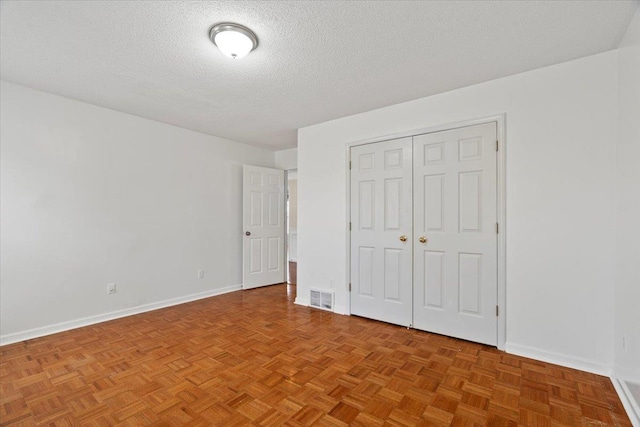 unfurnished bedroom with baseboards, a closet, visible vents, and a textured ceiling