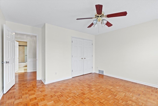 unfurnished bedroom with a textured ceiling, a closet, visible vents, and baseboards