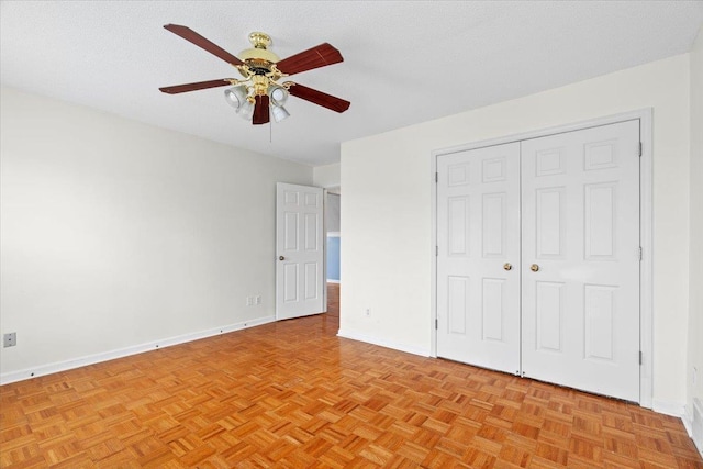 unfurnished bedroom featuring a ceiling fan, a closet, a textured ceiling, and baseboards