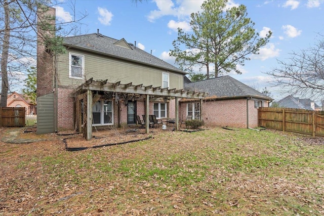 rear view of property featuring brick siding, a lawn, fence, and a pergola