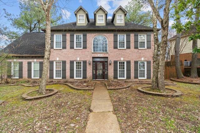 colonial inspired home featuring brick siding