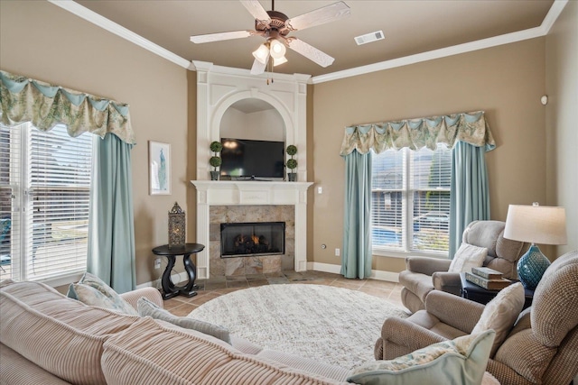 tiled living room featuring plenty of natural light, a tile fireplace, and ornamental molding