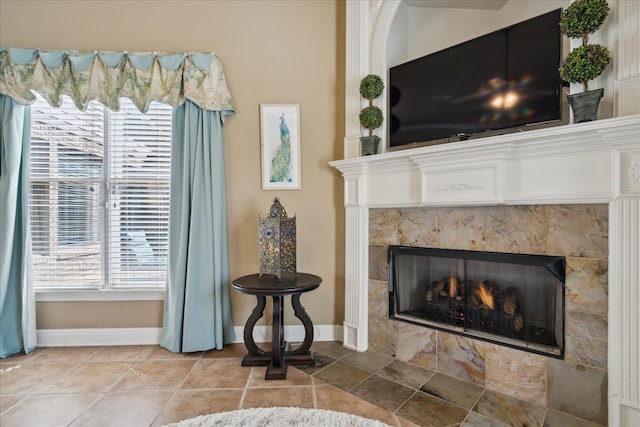 living room with a tiled fireplace and tile patterned floors