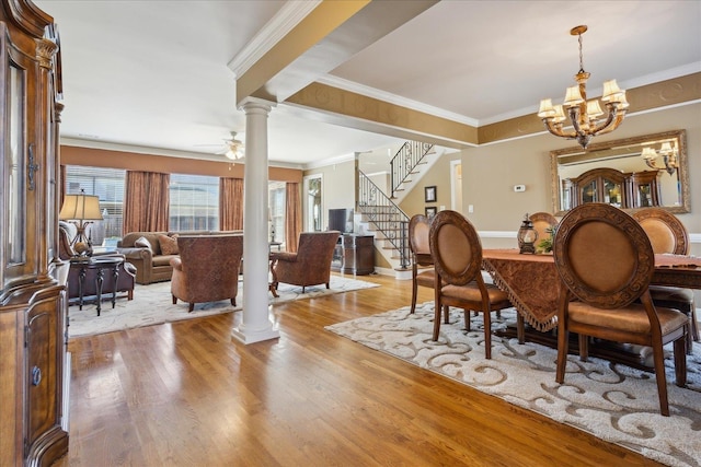 dining space with ceiling fan with notable chandelier, crown molding, light hardwood / wood-style floors, and ornate columns