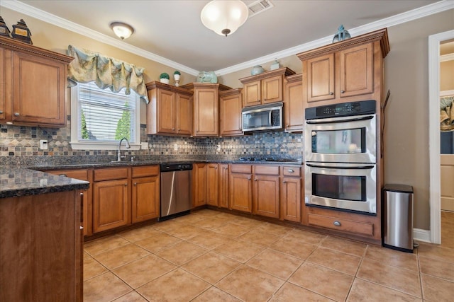 kitchen featuring decorative backsplash, light tile patterned floors, appliances with stainless steel finishes, and ornamental molding