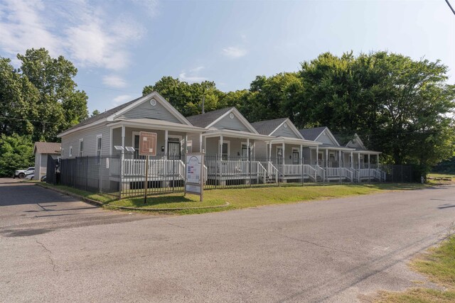 view of front of house featuring a porch, fence, and a front yard