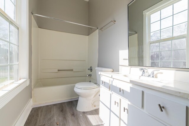 full bathroom with a wealth of natural light, hardwood / wood-style flooring, toilet, and vanity