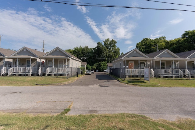 view of front of home featuring covered porch, driveway, and a front yard