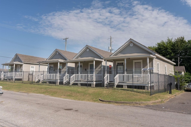 view of front of home with a porch, a front lawn, and roof with shingles