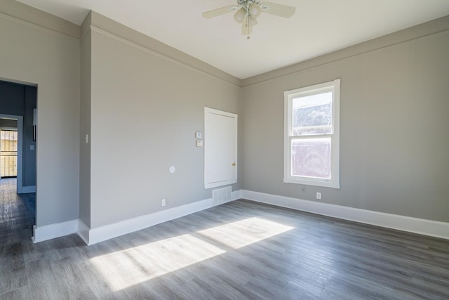 unfurnished room featuring visible vents, a ceiling fan, baseboards, and wood finished floors