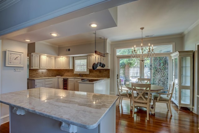 kitchen with visible vents, ornamental molding, decorative light fixtures, and tasteful backsplash