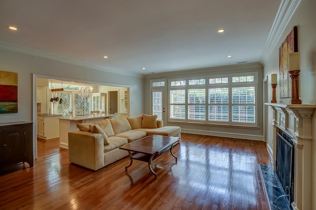 living room with ornamental molding, recessed lighting, a fireplace, and dark wood finished floors