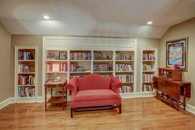 living area featuring lofted ceiling, baseboards, light wood finished floors, and recessed lighting