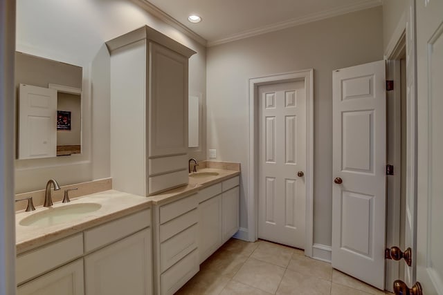 full bath featuring double vanity, tile patterned flooring, crown molding, and a sink