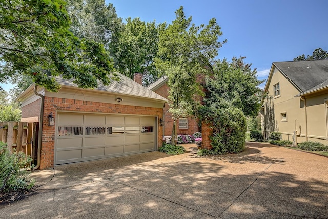 view of front facade with brick siding, a chimney, a shingled roof, fence, and driveway