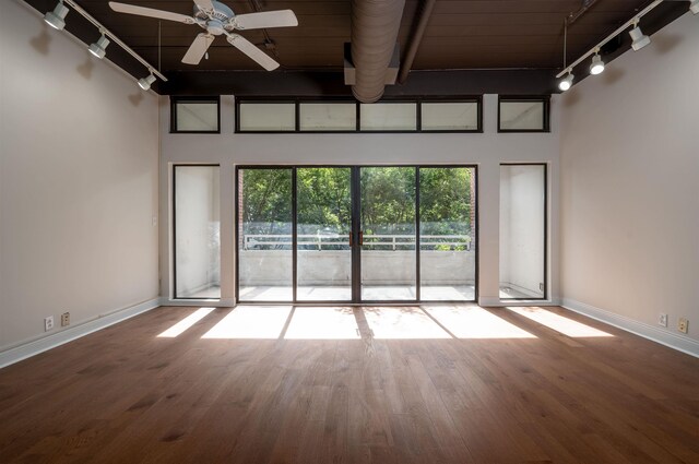 empty room featuring ceiling fan, hardwood / wood-style floors, and rail lighting