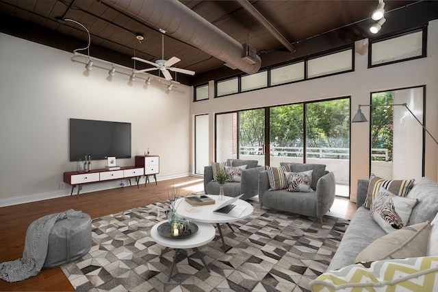 living room with beam ceiling, light hardwood / wood-style floors, rail lighting, wood ceiling, and ceiling fan