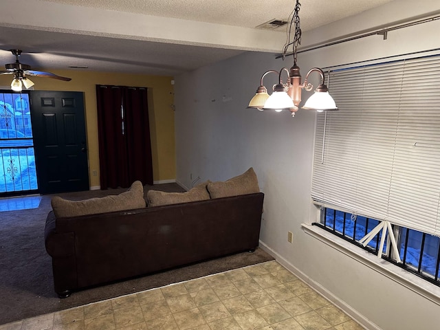 795 Williams Ave, Memphis, TN 38126 - carpeted living area featuring baseboards, a ceiling fan, a textured ceiling, and a chandelier