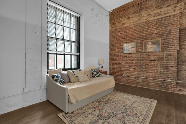 interior space featuring brick wall and dark wood-type flooring