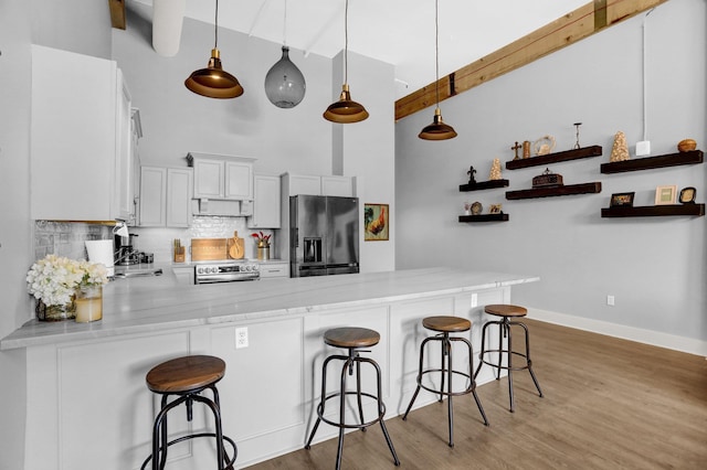 kitchen with white cabinets, pendant lighting, a peninsula, open shelves, and black fridge