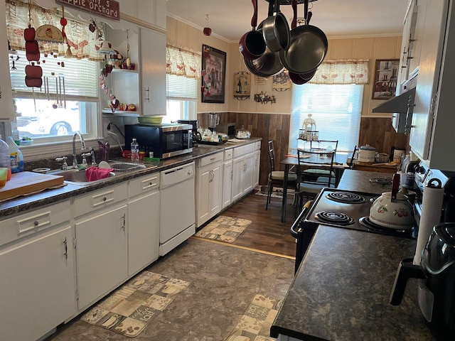 kitchen with dark hardwood / wood-style flooring, white cabinetry, dishwasher, sink, and crown molding