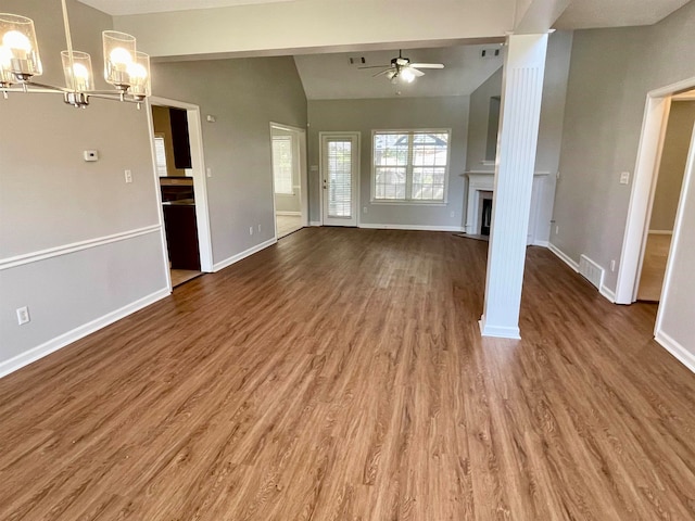 unfurnished living room featuring ceiling fan with notable chandelier, lofted ceiling, and wood-type flooring