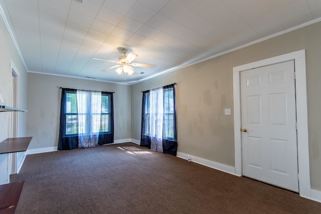 spare room featuring crown molding, dark carpet, and ceiling fan