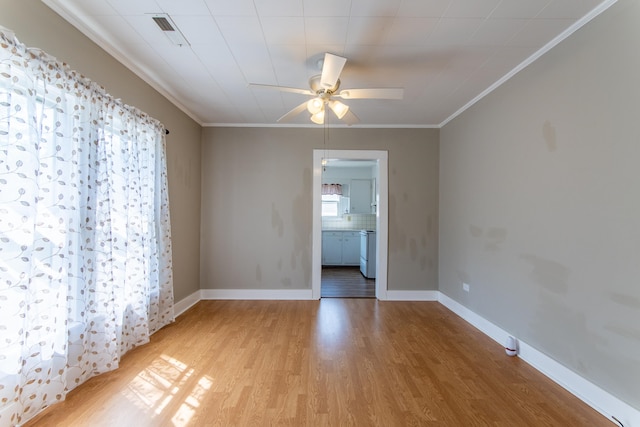 spare room featuring light wood-type flooring, ornamental molding, and ceiling fan